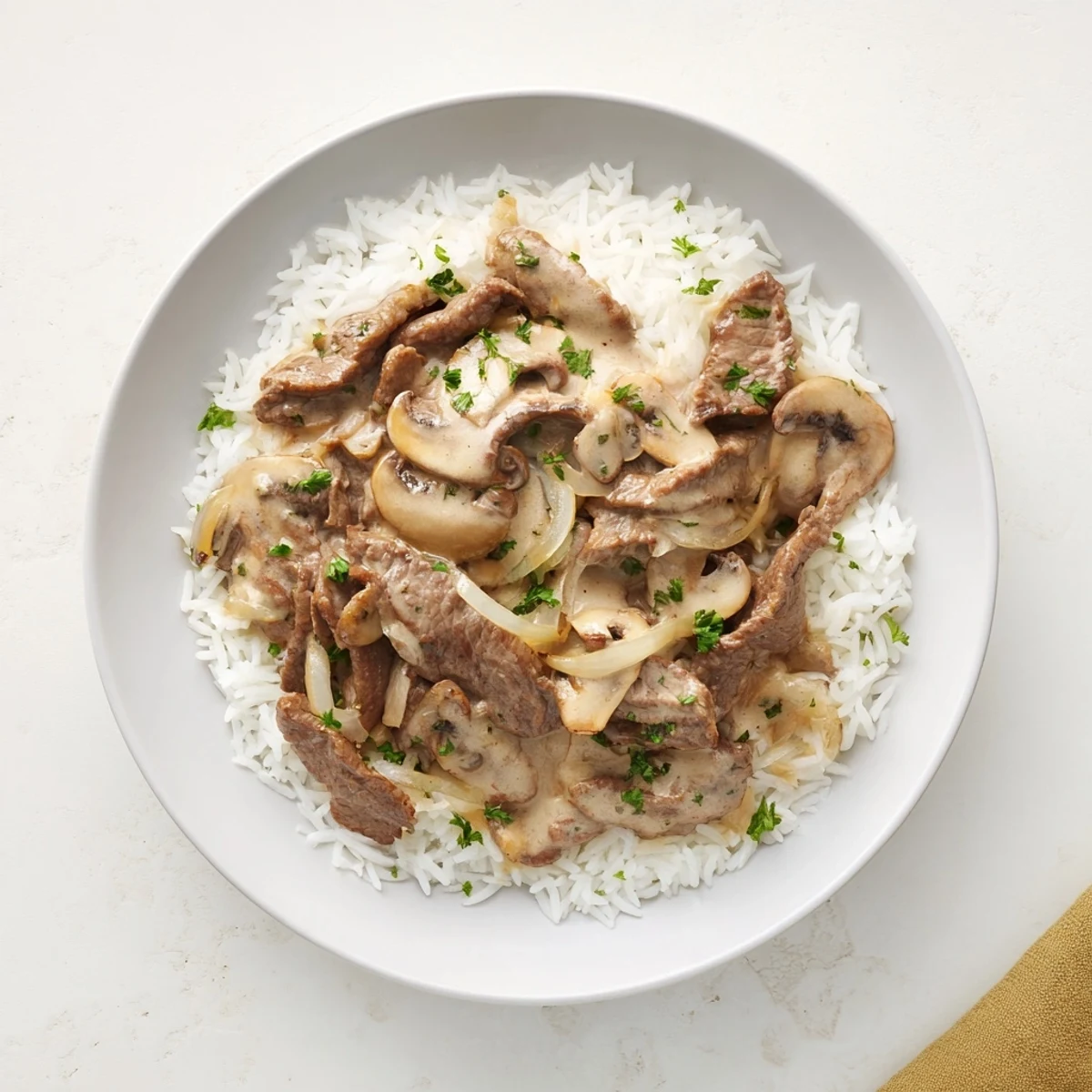 Close-up of Beef Stroganoff with creamy sauce, mushrooms, and tender beef, served on fluffy rice.