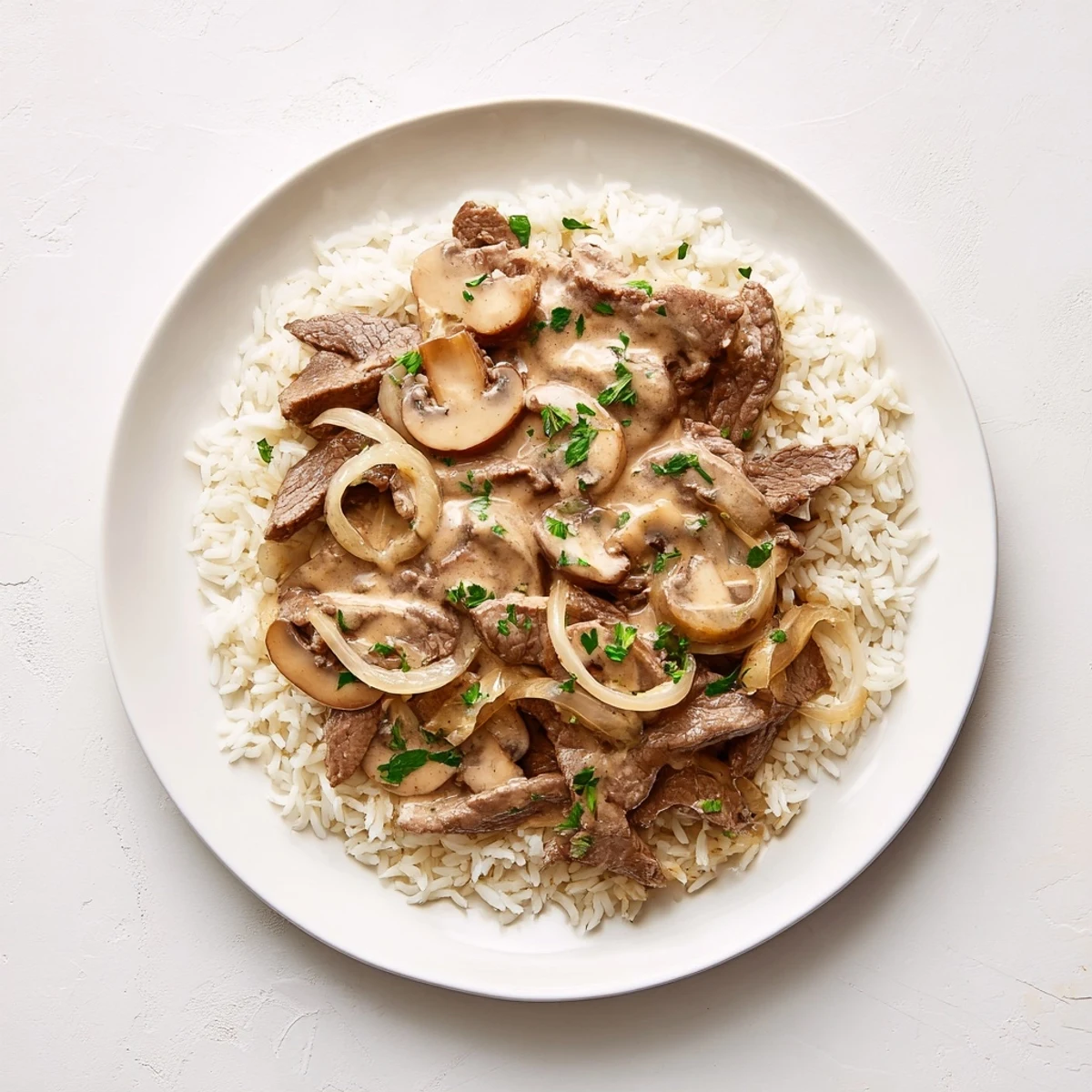 Fluffy white rice topped with flavorful Beef Stroganoff, perfect for a cozy, satisfying dinner.