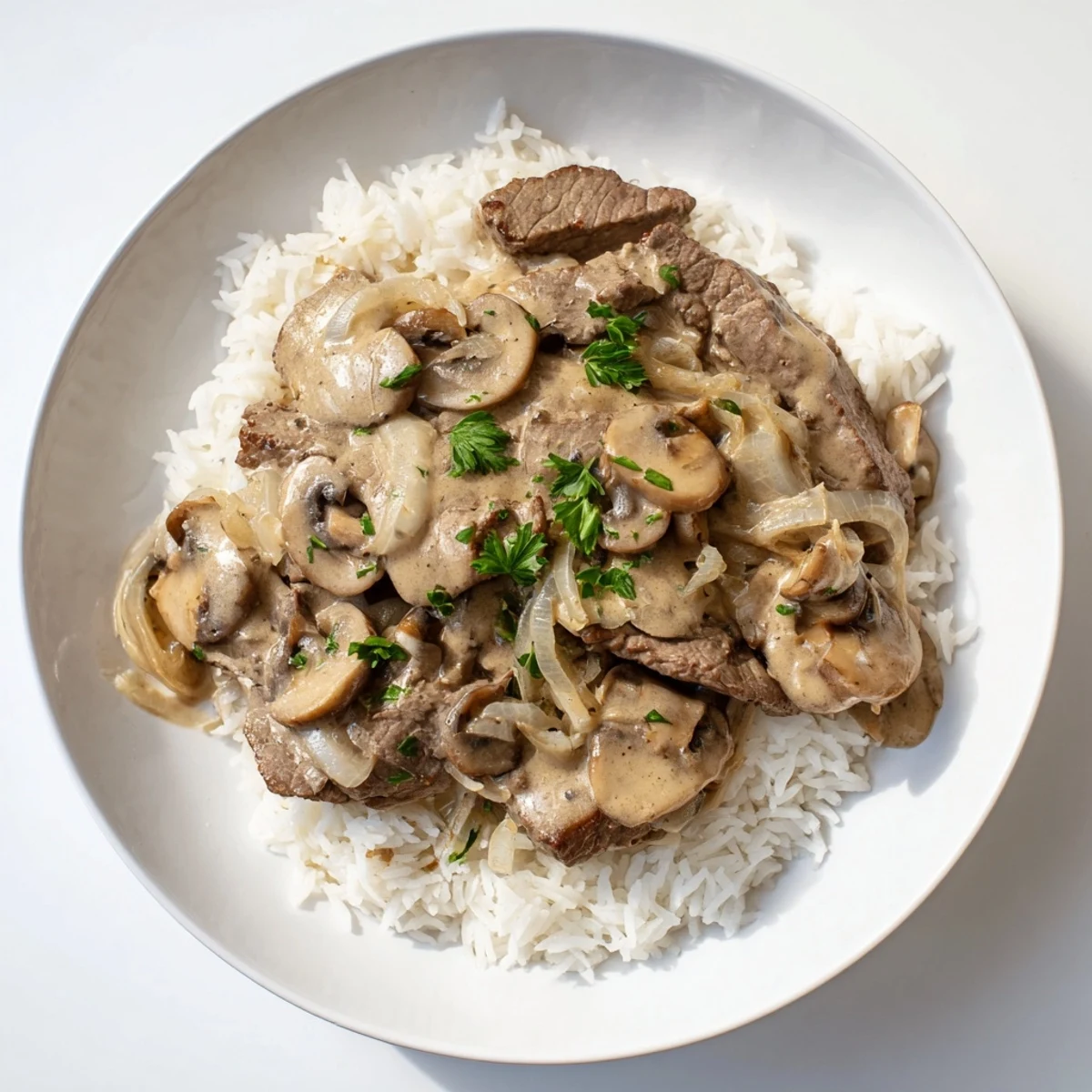 A hearty bowl of Beef Stroganoff—juicy beef in a rich sauce, ready to be enjoyed over white rice.