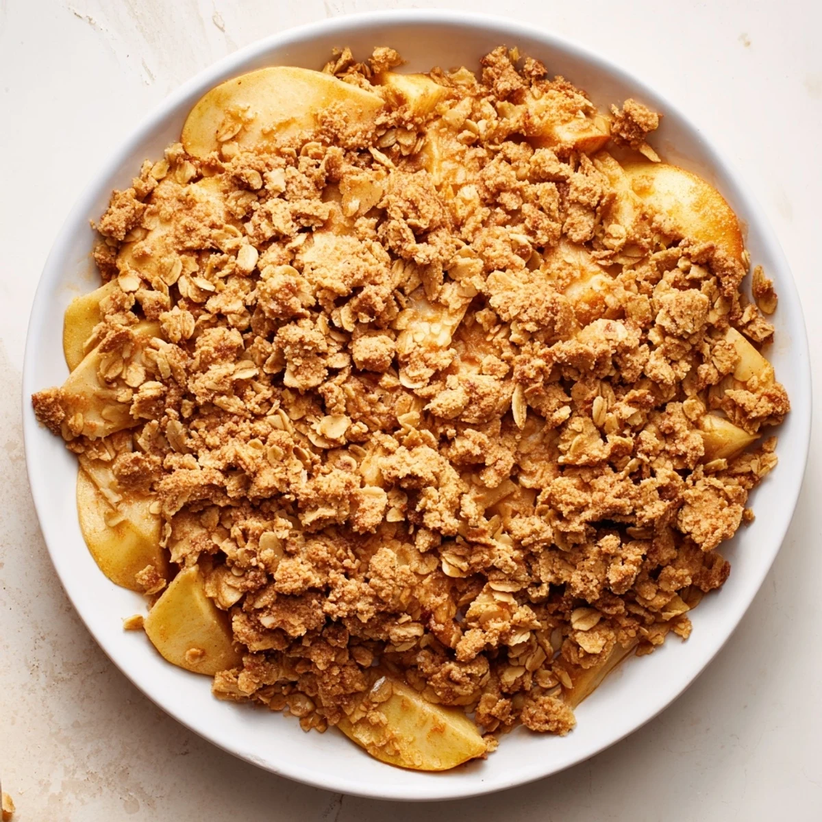 A close-up of a rustic, fragrant baked apple crumble, perfect with vanilla ice cream.