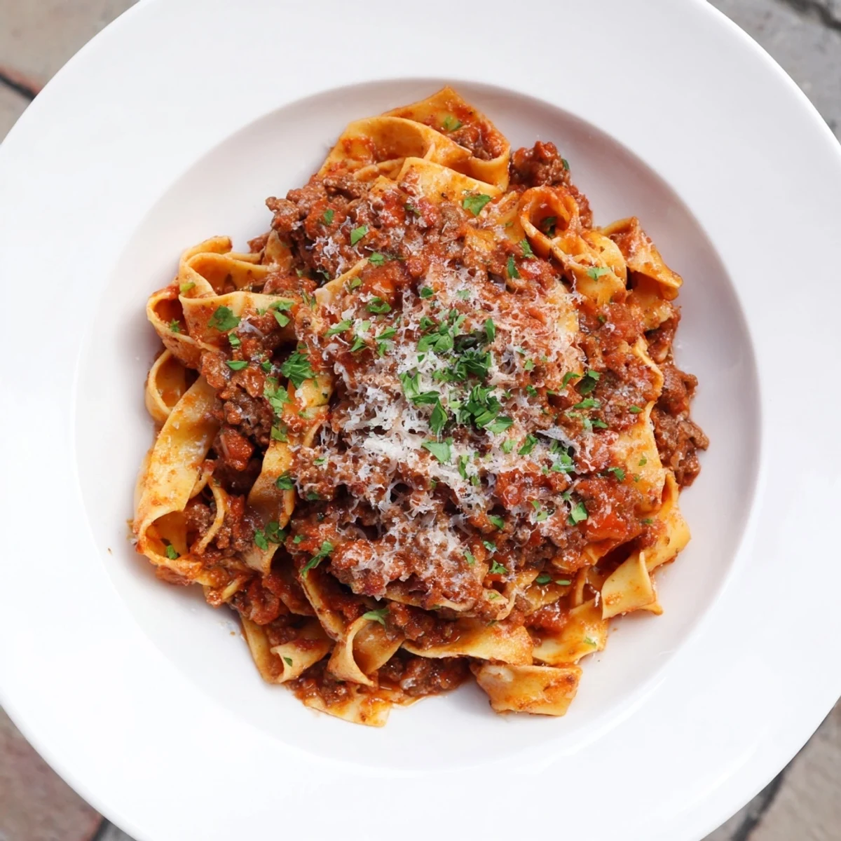Creamy Beef Bolognese with tagliatelle, a comforting Italian pasta dish drizzled with Parmesan.