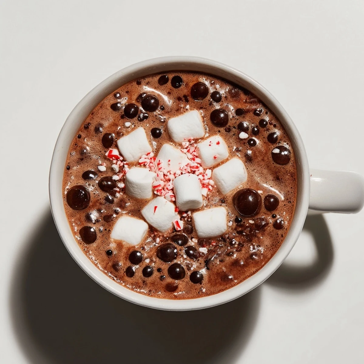 Enjoy the delightful indulgence, a beautifully presented peppermint hot cocoa with melting marshmallows on top.