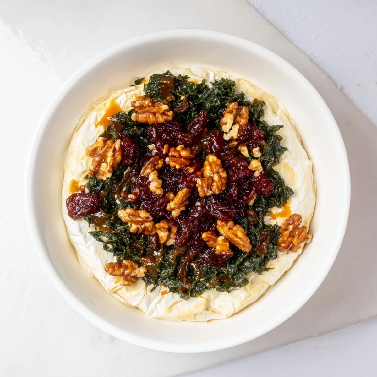 Close-up shot shows decadent, cheesy Baked Brie glistening after being baked in flaky pastry.