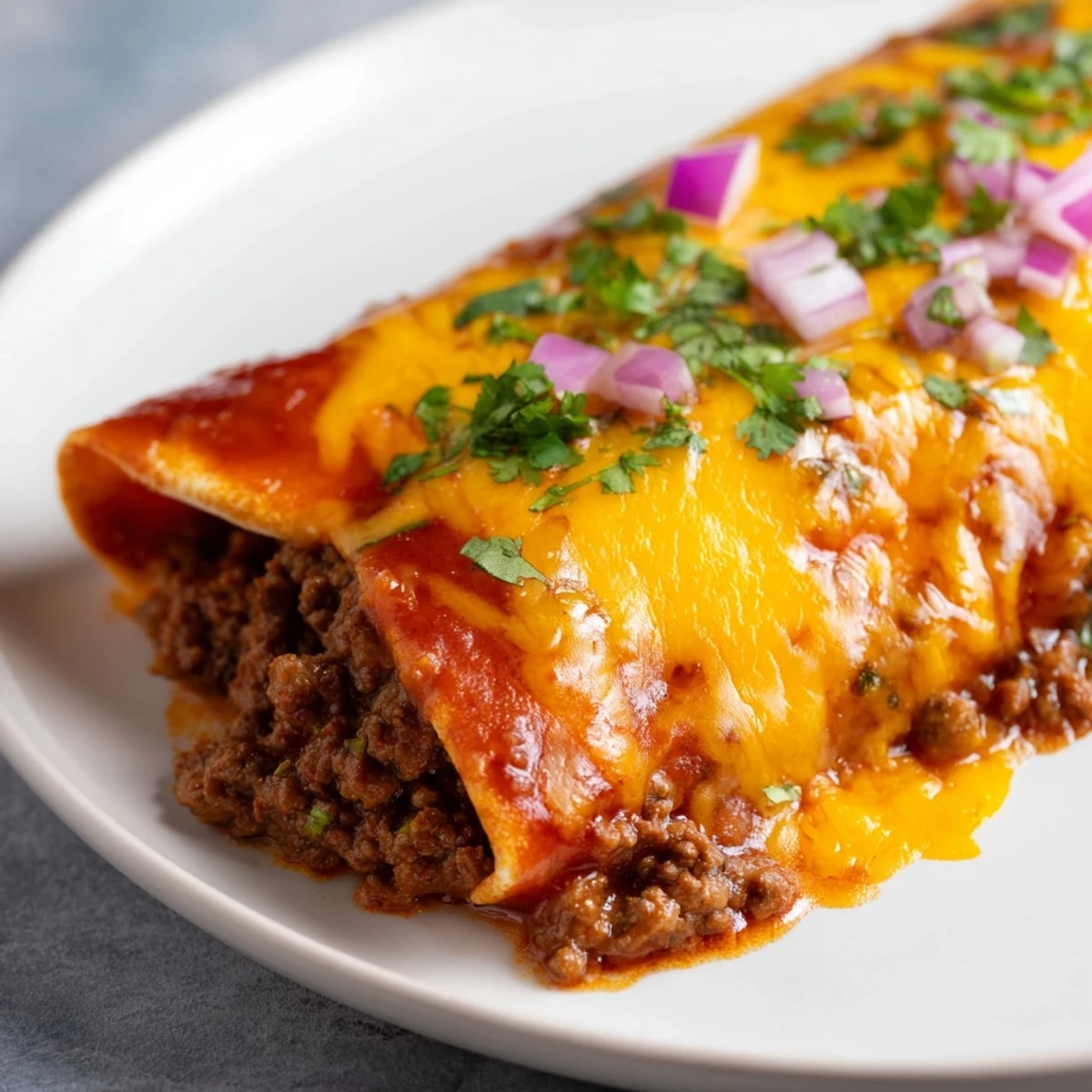 Golden, bubbly Beef Enchiladas with red sauce, cheese melted over warm tortillas, ready to eat!