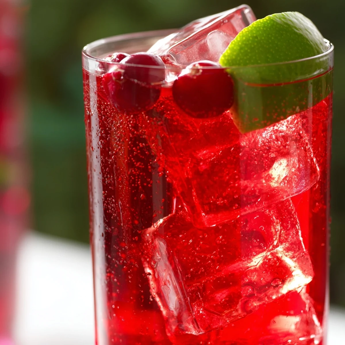 Two chilled glasses of Cranberry Juice Cocktail with Lime, poured with ice and a bright citrus garnish.