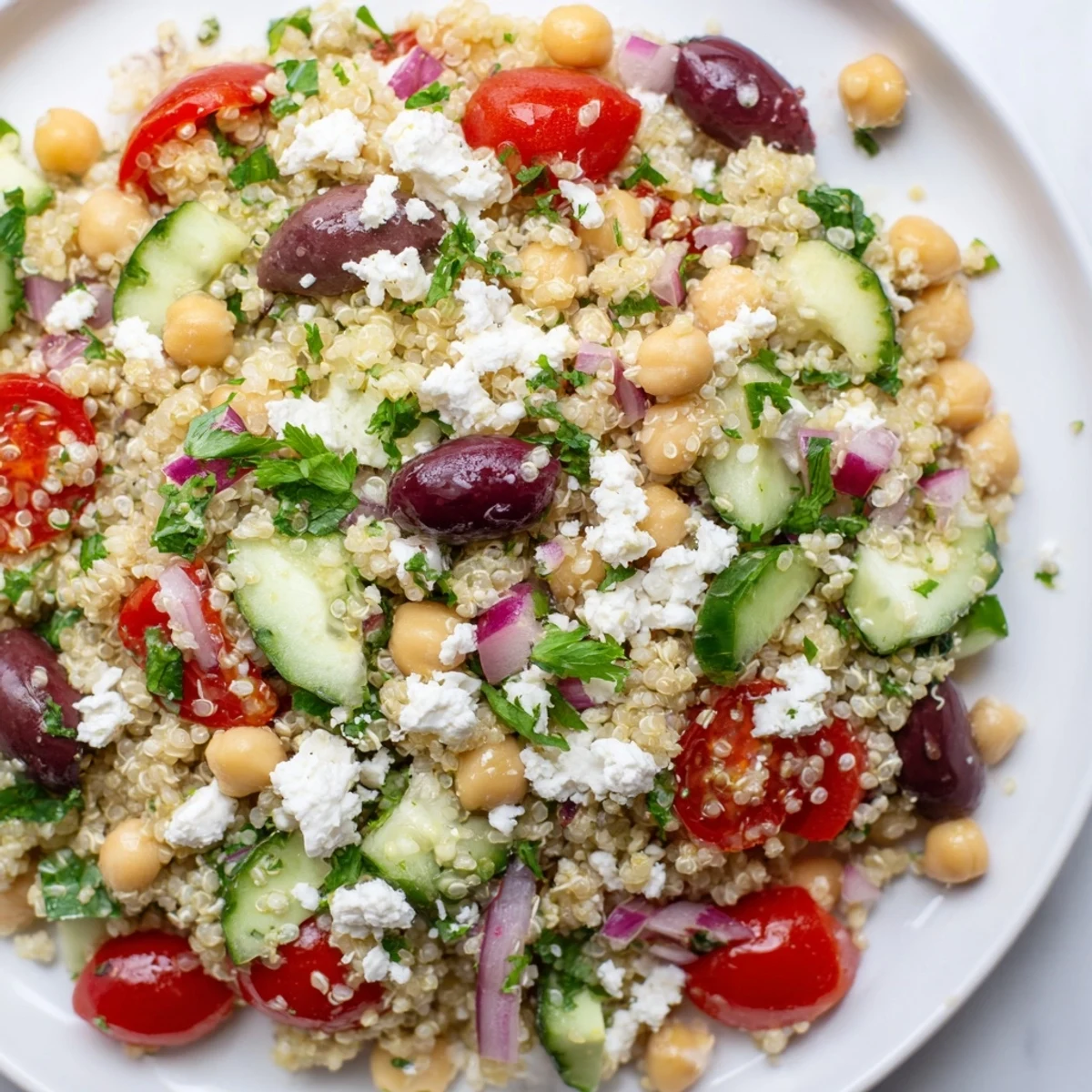 Close-up Mediterranean Quinoa Salad with Chickpeas showing fluffy quinoa, diced bell peppers, and zesty lemon-herb dressing drizzled over the top.