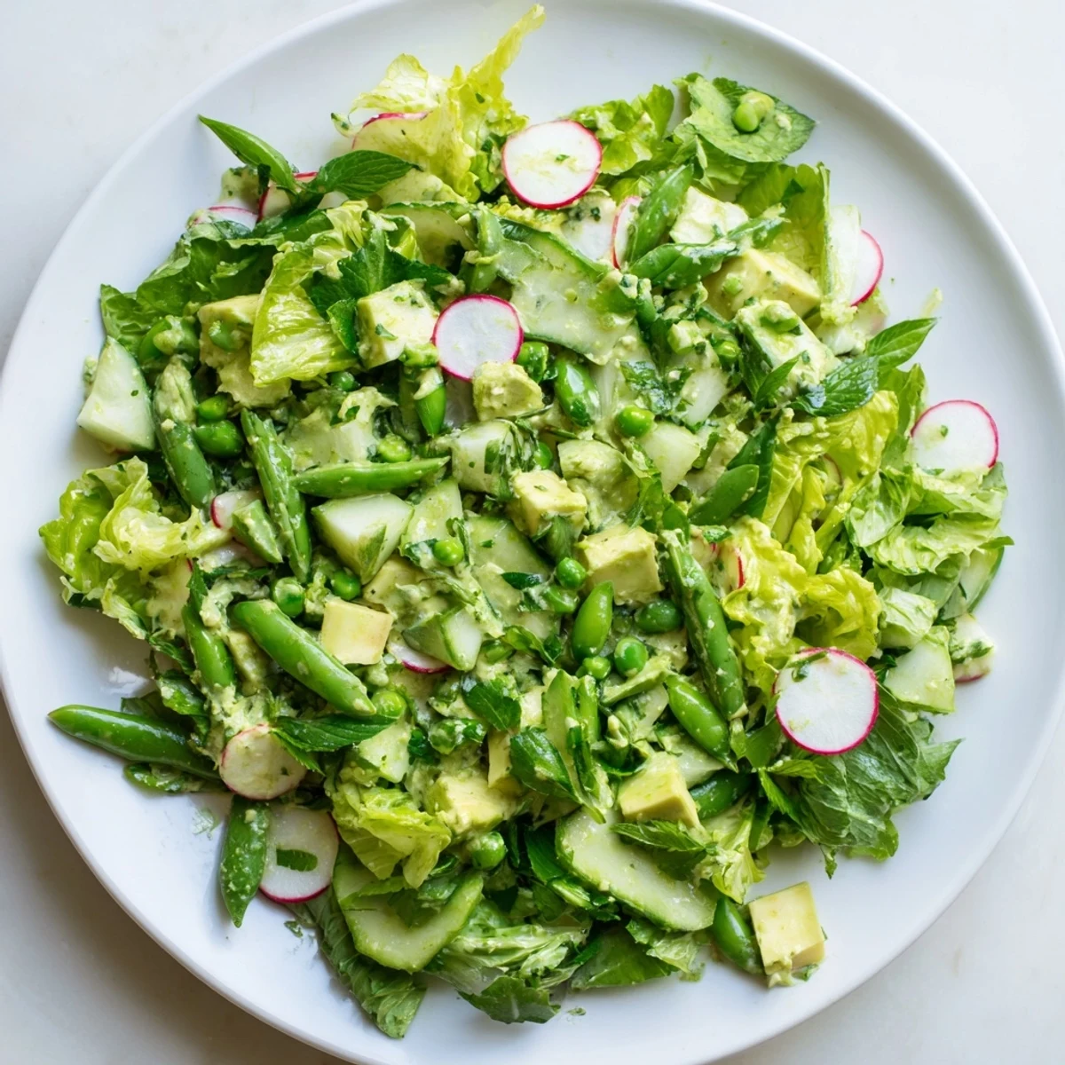 Freshly blended avocado Green Goddess Salad with Avocado Dressing garnished with chives and parsley, ready to serve.