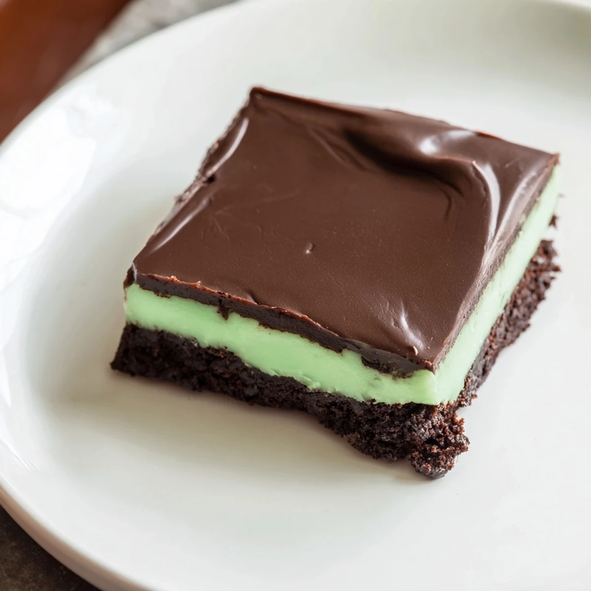 Stack of Shamrock Mint Brownies with Chocolate Ganache showing fudgy layers, mint cream, and a drizzle of ganache.