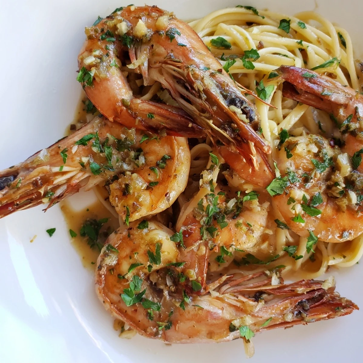 A rustic skillet of Lemon Garlic Butter Shrimp with Pasta, sautéed shrimp nestled in a creamy, garlicky, citrusy sauce.