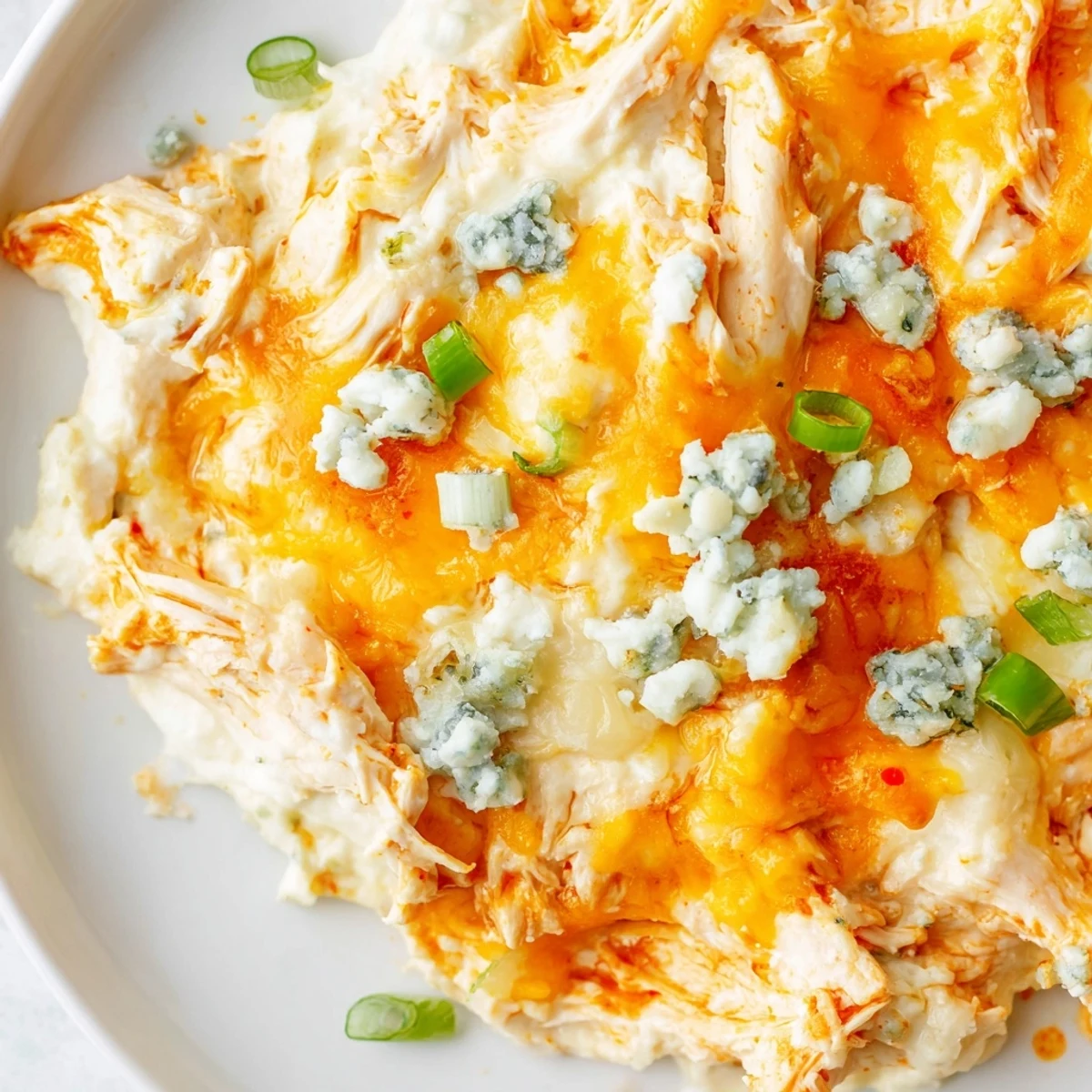 Spoon lifting a cheesy scoop of Keto Buffalo Chicken Dip, showing tender chicken and a rich, low-carb appetizer texture.
