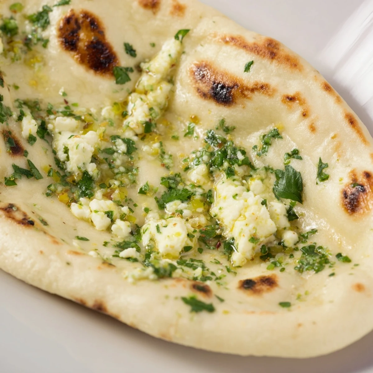 Freshly cooked Cottage Cheese Garlic Naan with golden-brown spots brushed in melted garlic butter.