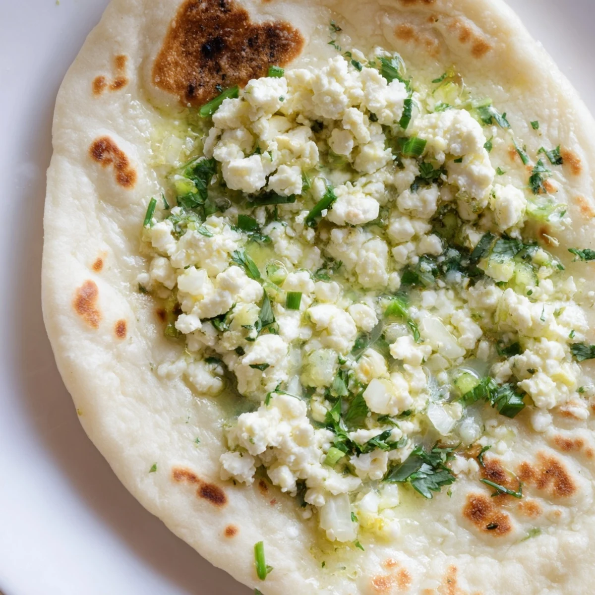 Soft Cottage Cheese Garlic Naan stuffed with creamy cottage cheese and fresh cilantro, served warm.