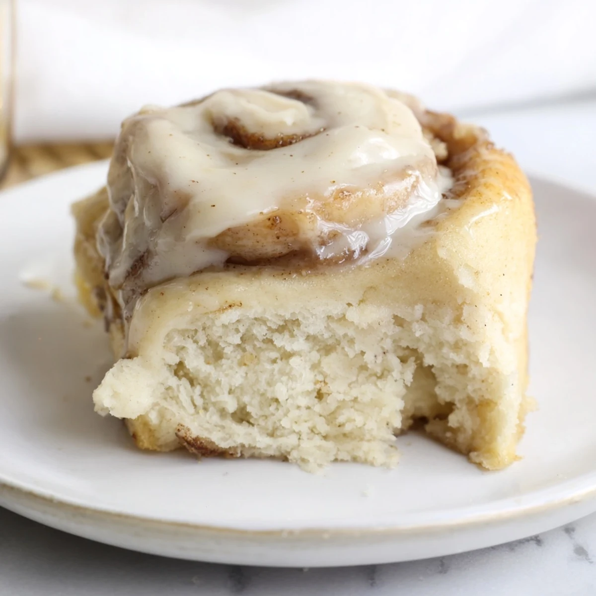 Warmly glazed Keto Cinnamon Buns sit on a wooden board, ready to be enjoyed for a low-carb treat.