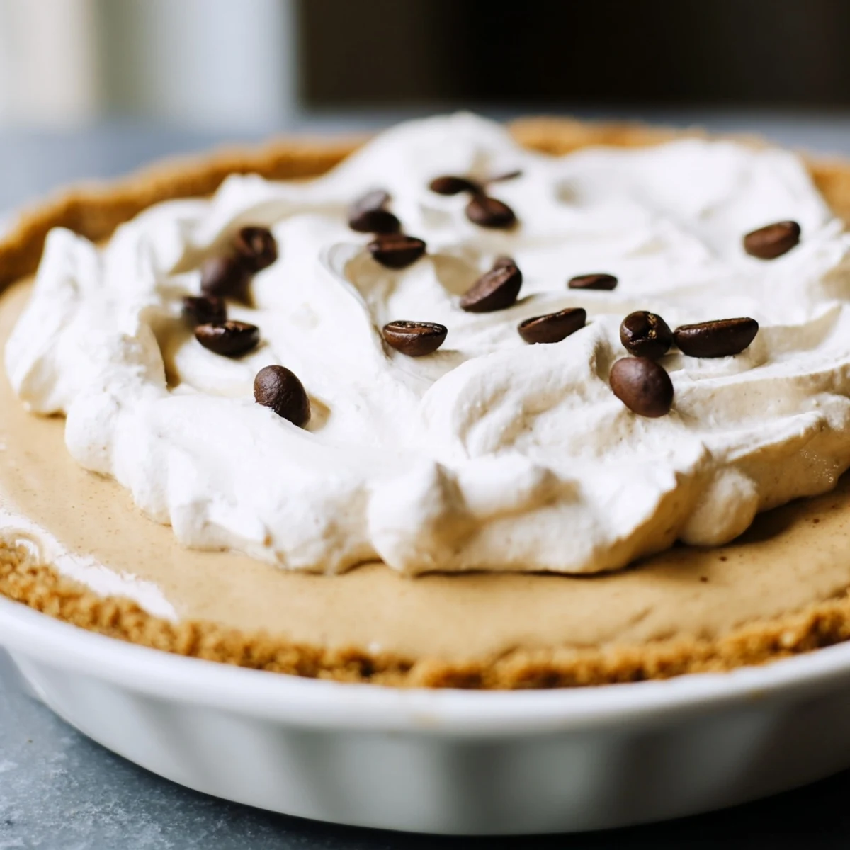 A chilled Keto Cold Brew Coffee Pie is served on a plate, garnished with cocoa powder and perfect for a low-carb dessert.