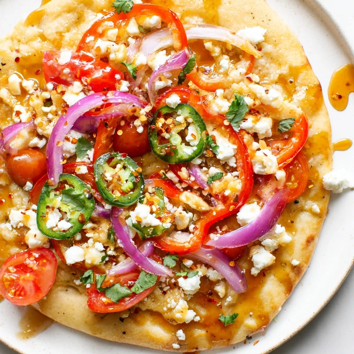 Freshly baked Sweet Heat Honey Garlic Flatbread Pizza drizzled with extra honey, sliced on a wooden board for a delicious vegetarian main dish.