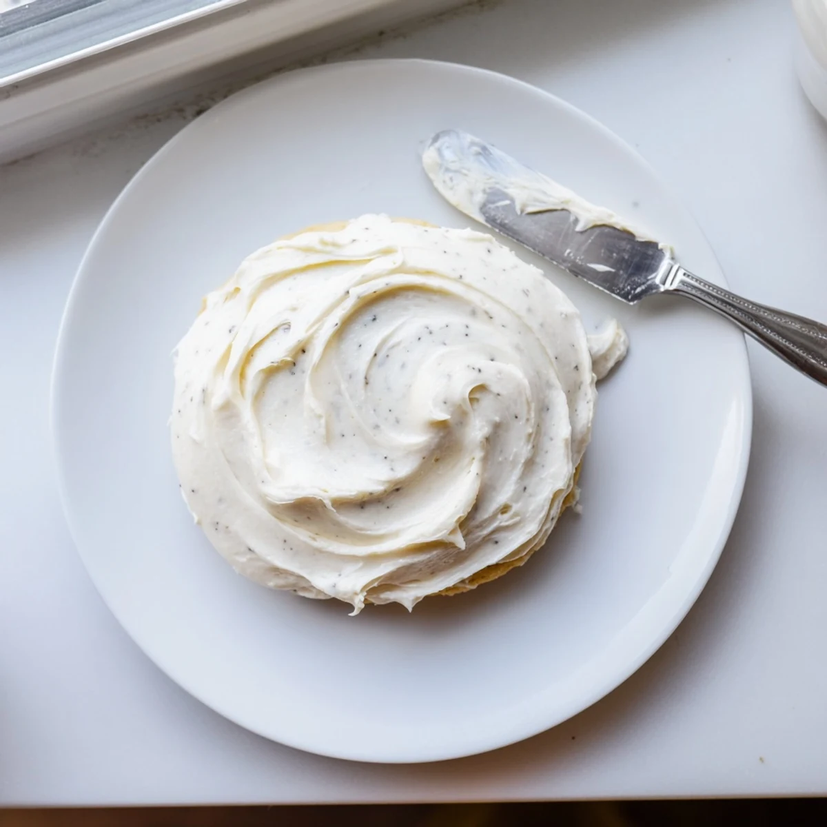 Easy Sugar Cookie Frosting being piped onto freshly baked sugar cookies with a decorating bag.