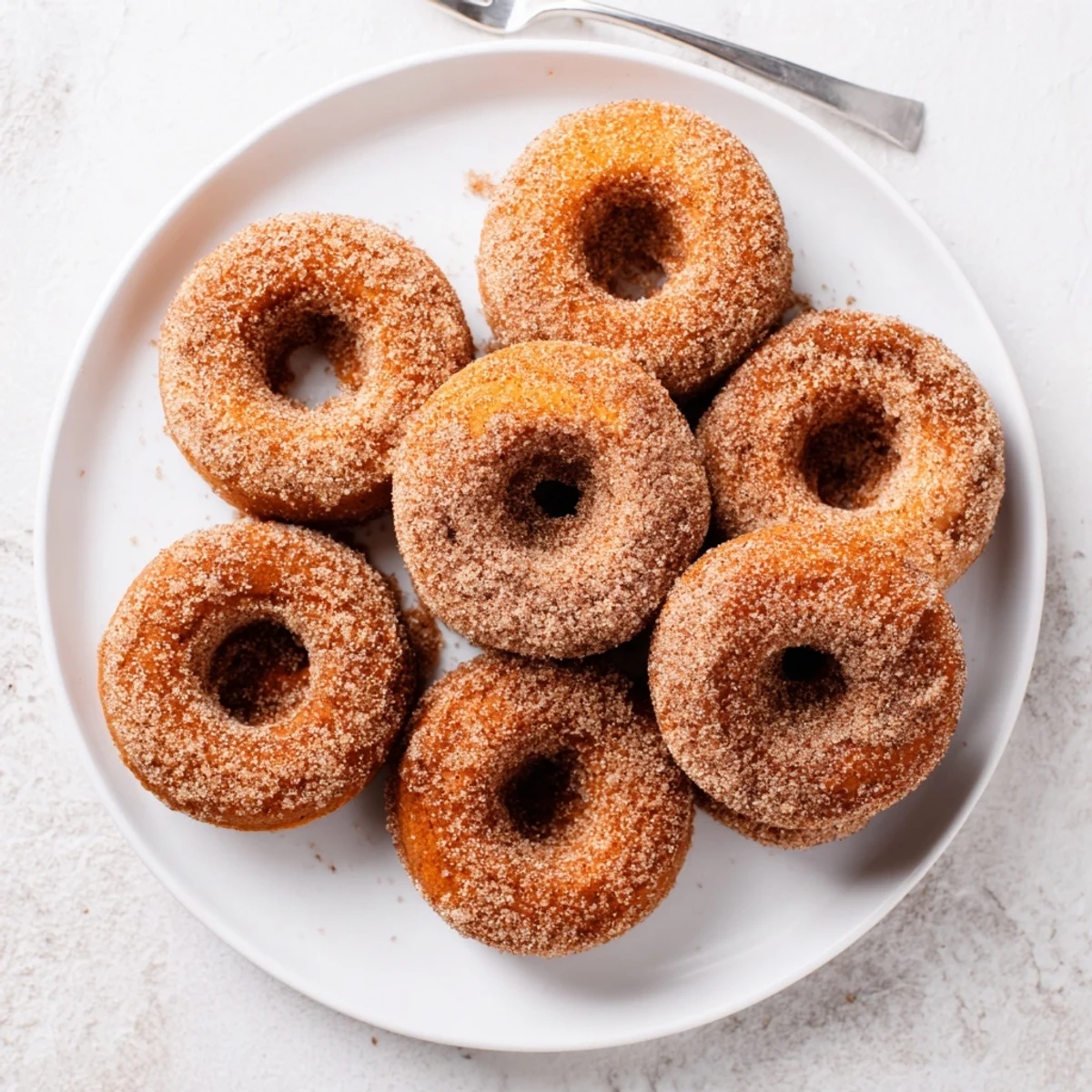 A close up of warm Delicious Baked Cinnamon Sugar Donuts You Cant Resist, brushed with butter and ready for breakfast.