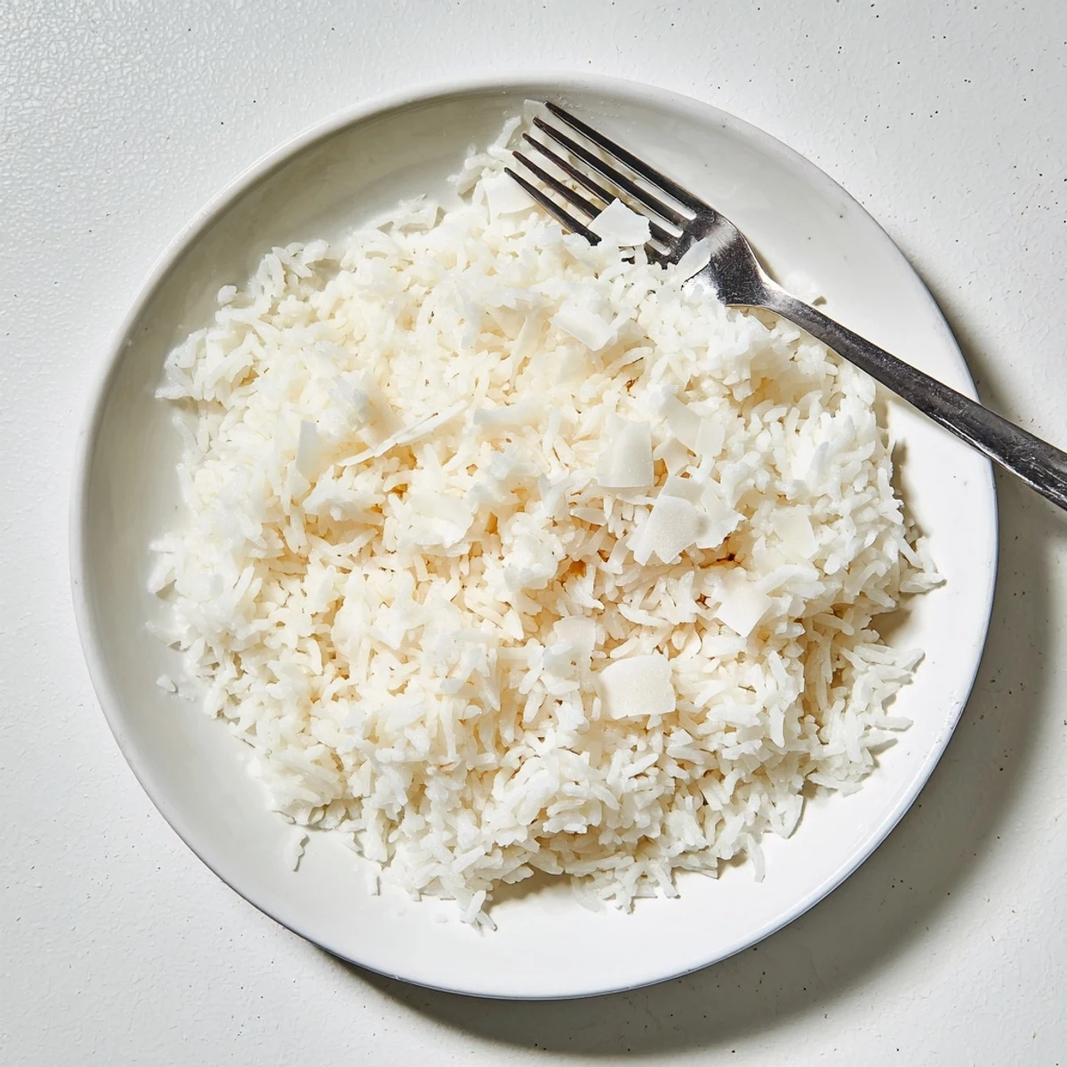 Serve The Best Coconut Rice with grilled chicken and fresh herbs for a comforting side dish.