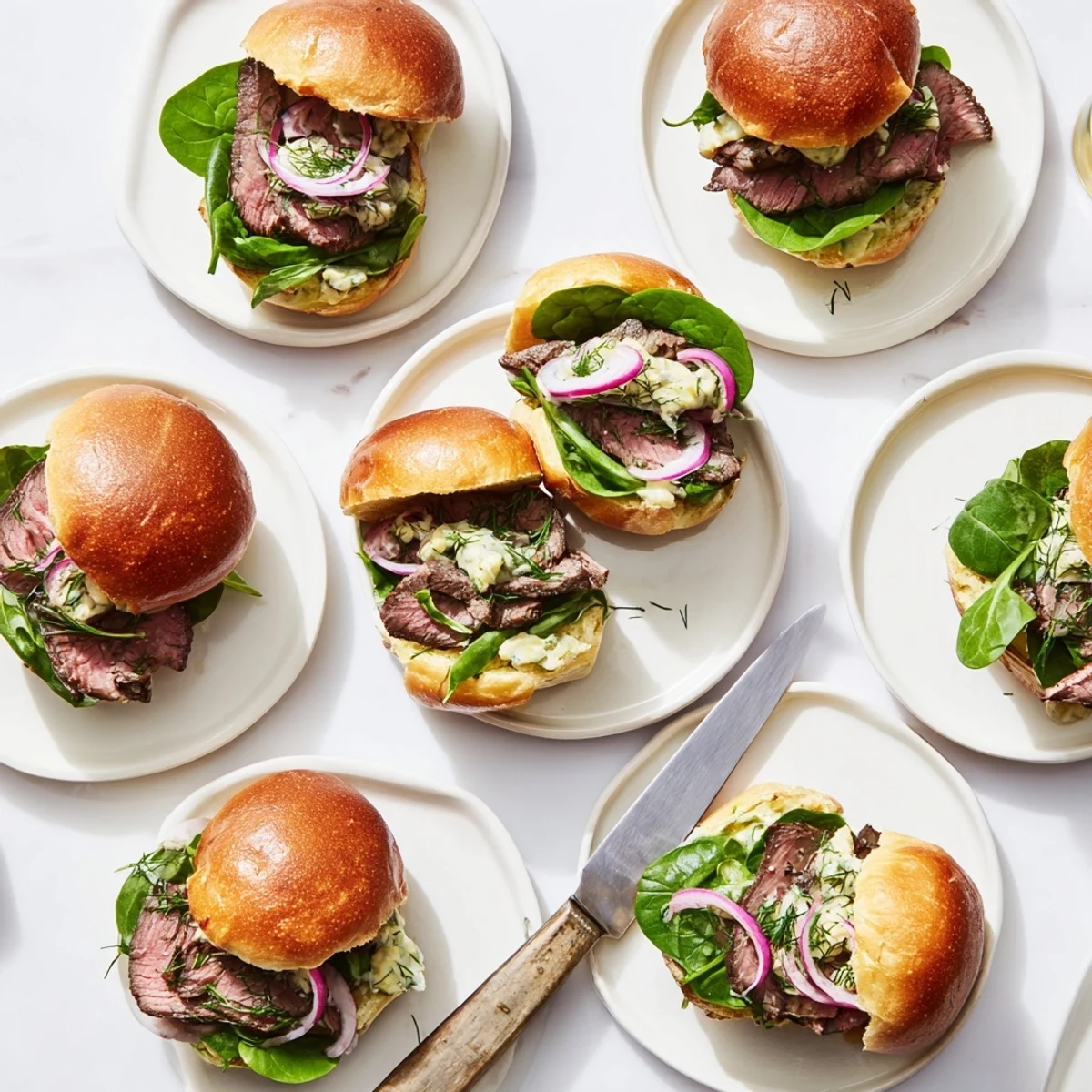 Freshly seared sliced steak layered on toasted slider buns with creamy homemade cowboy butter.