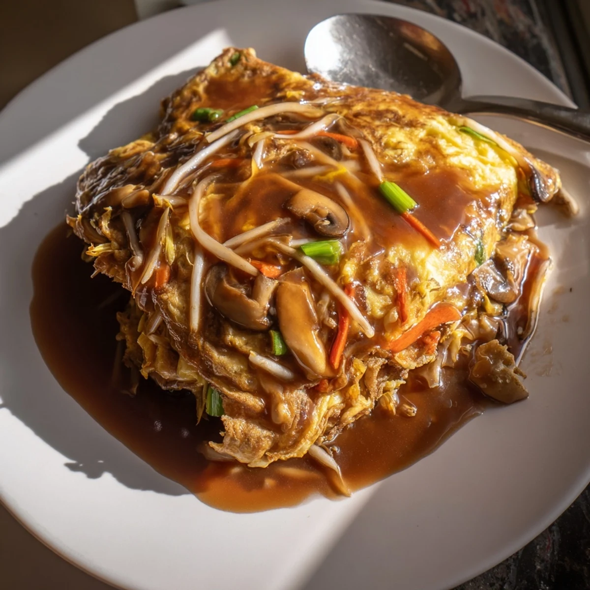 Fluffy Chinese-American Egg Foo Young omelet packed with colorful vegetables and meat, fried until perfectly crisp