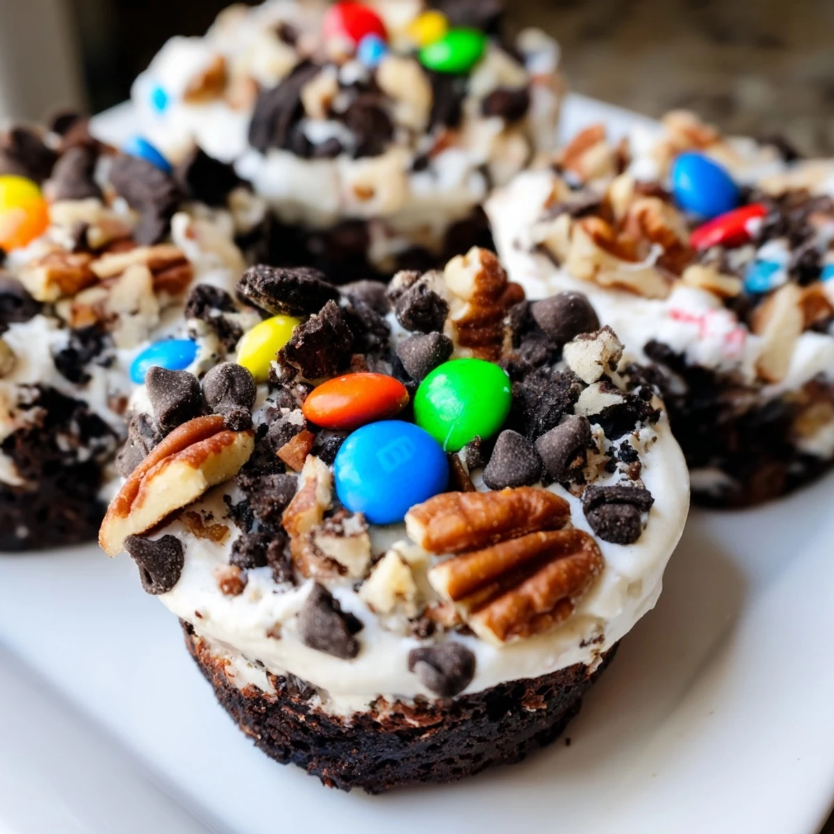 Rich fudgy loaded brownie cheesecake cups topped with colorful candy and chocolate chunks