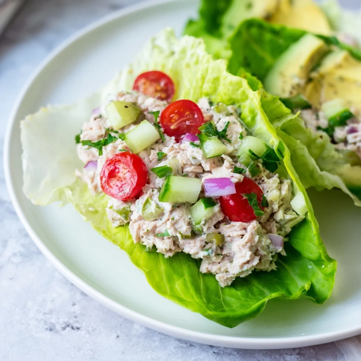 Creamy zesty tuna salad wraps featuring crunchy vegetables inside butter lettuce cups for lunch