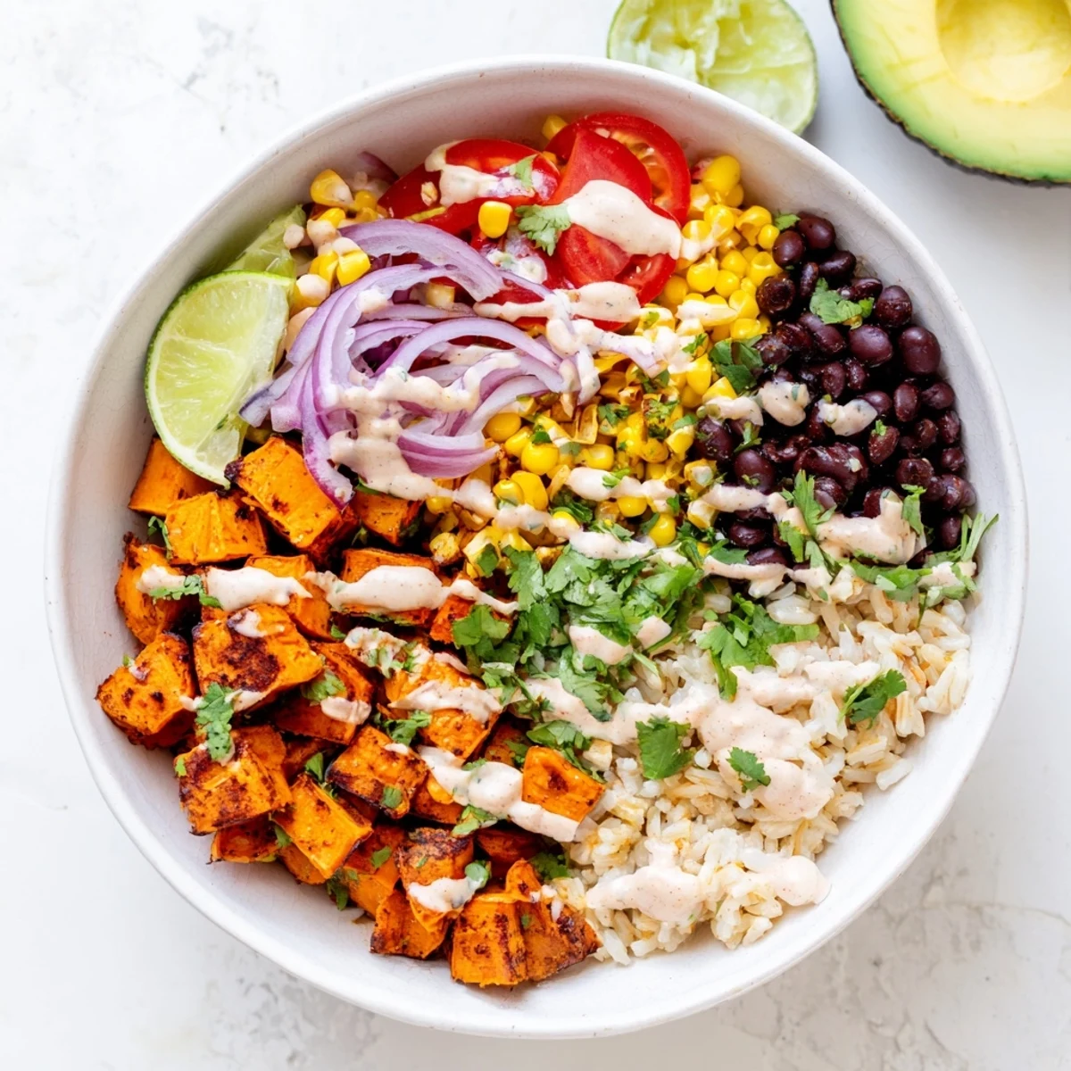 Colorful vegan sweet potato burrito bowl with roasted potatoes black beans and avocado