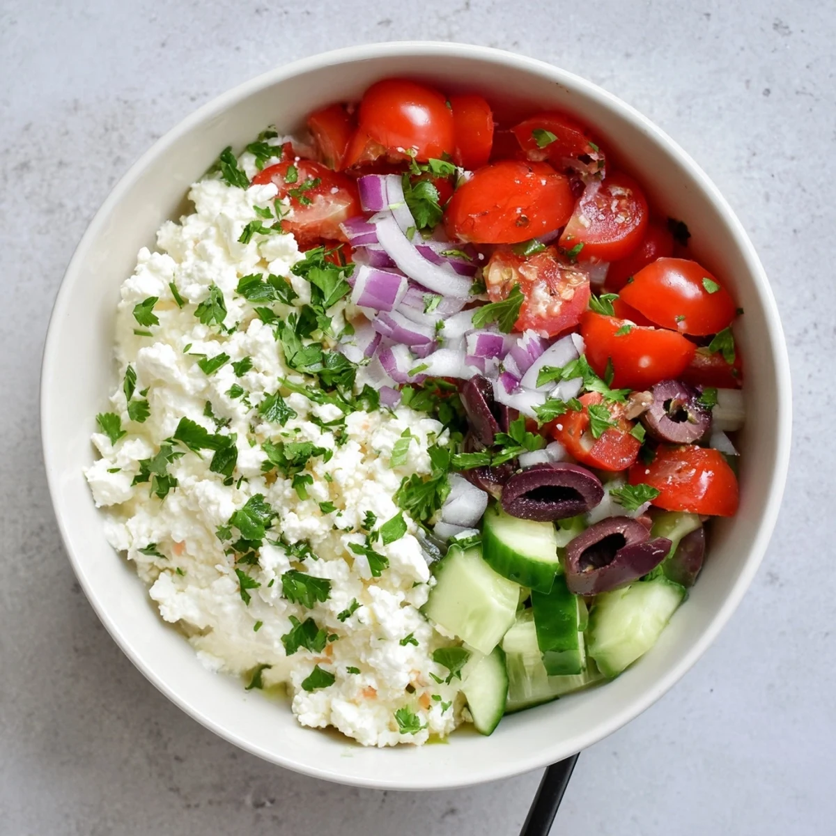 Creamy cottage cheese bowl layered with crisp cucumbers, tomatoes, and Mediterranean-style vegetables