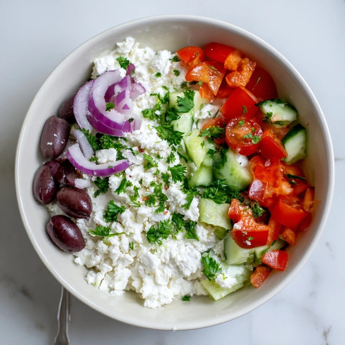 Protein-packed Greek salad cottage cheese bowl featuring vibrant veggies and tangy feta cheese topping