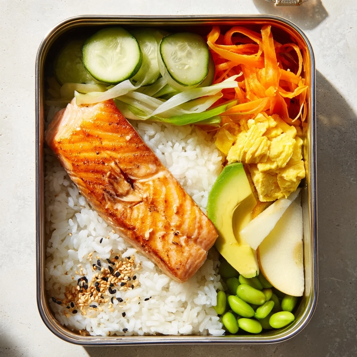 Homemade Japanese breakfast bento box showcasing grilled salmon fillet beside fluffy white steamed rice