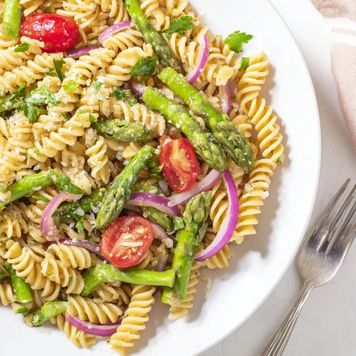 Bright lemon asparagus pasta salad featuring al dente noodles, crisp vegetables, and zesty herb dressing on a rustic wooden table