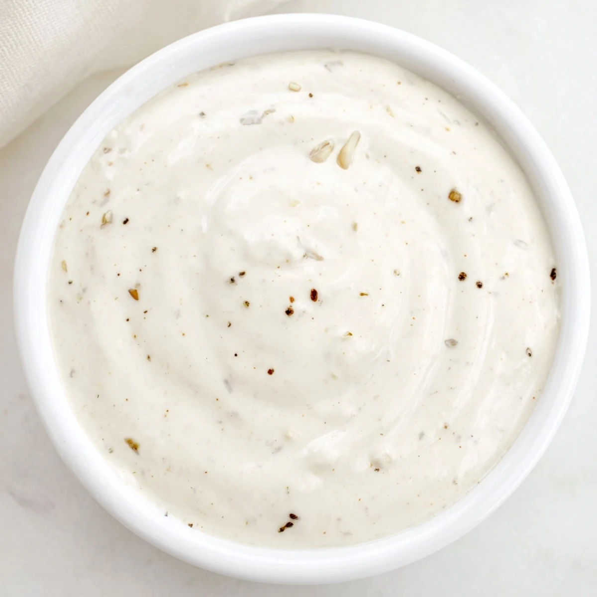 Thick white garlic sauce dip alongside grilled chicken shawarma wrap and vegetables