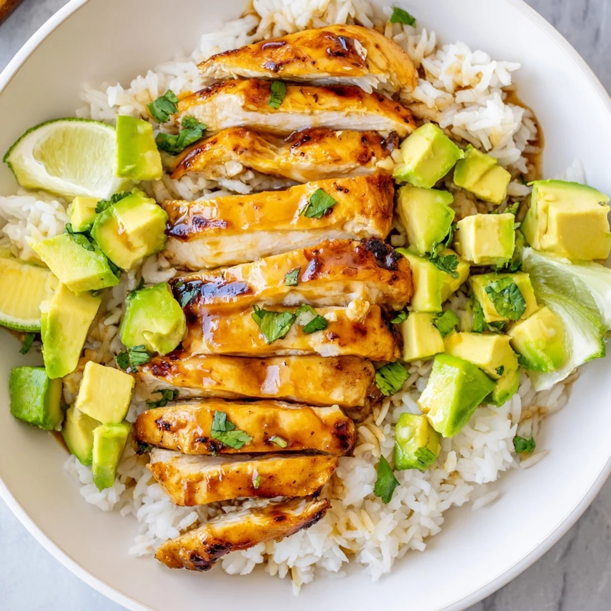 Golden honey lime chicken served over creamy avocado rice with fresh cilantro garnish