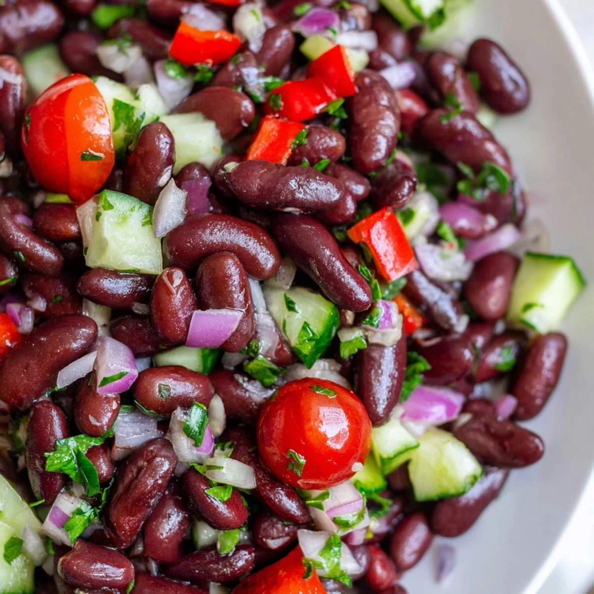 Creamy kidney bean salad with diced peppers and tomatoes in a rustic serving bowl