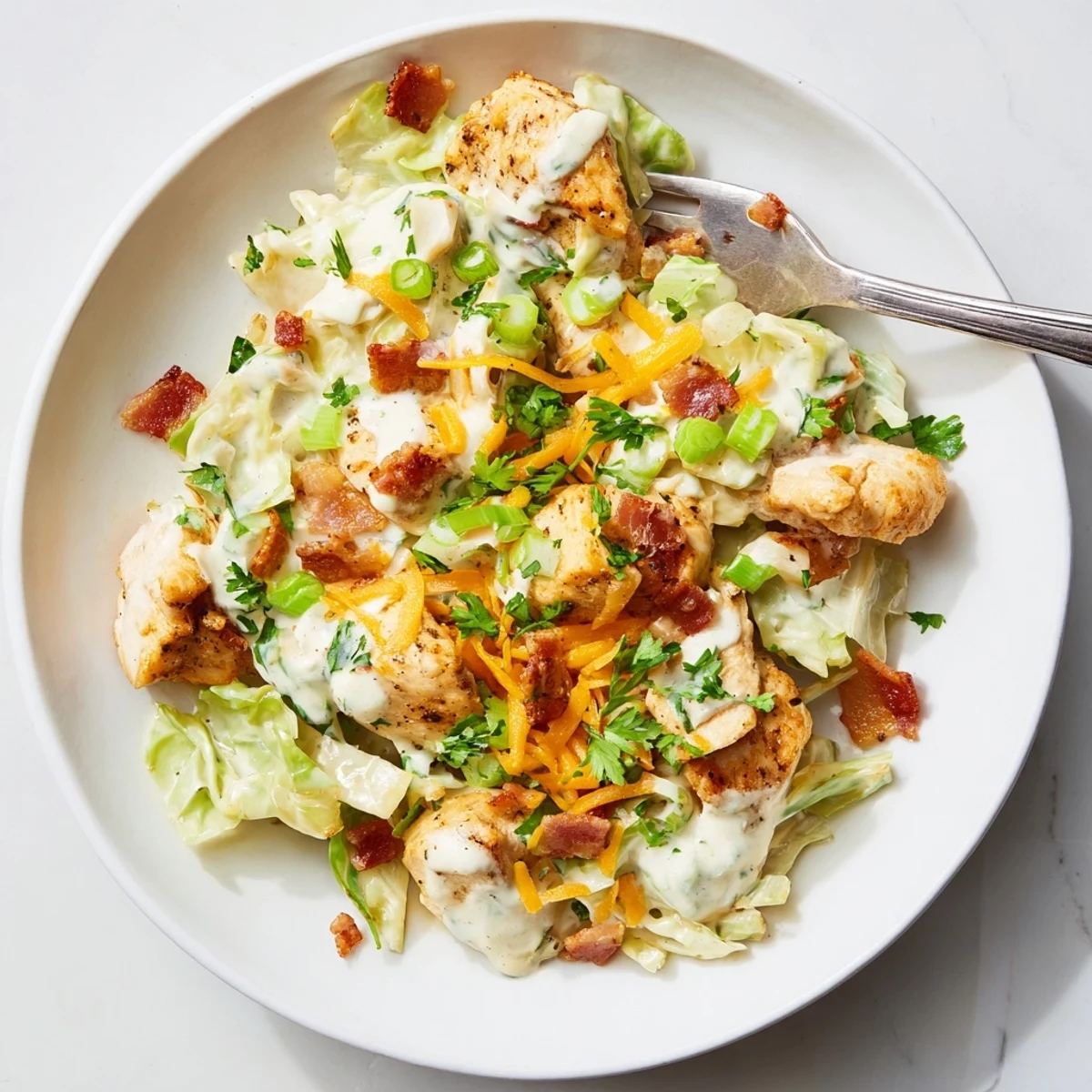 Creamy chicken bacon ranch cabbage bowls with tender meat and crispy bacon in white sauce