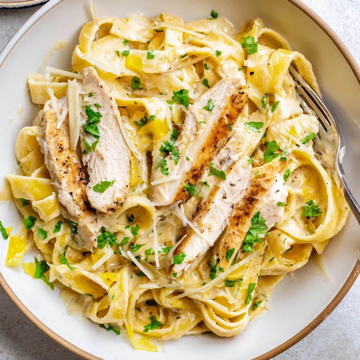 Creamy Garlic Chicken Pasta piled on plate, golden chicken, silky sauce