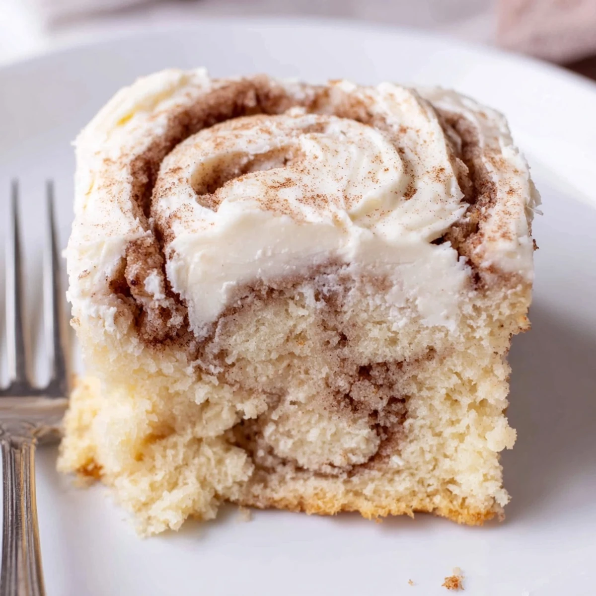Warm Cinnamon Roll Poke Cake sliced, buttery swirls oozing, perfect for brunch