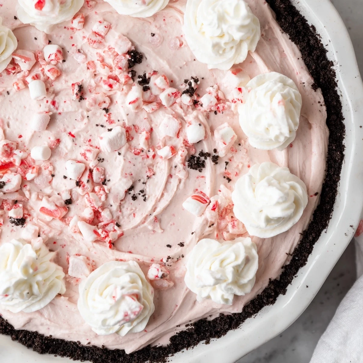 Candy Cane Pie with creamy peppermint filling, chocolate cookie crust, crushed candy topping