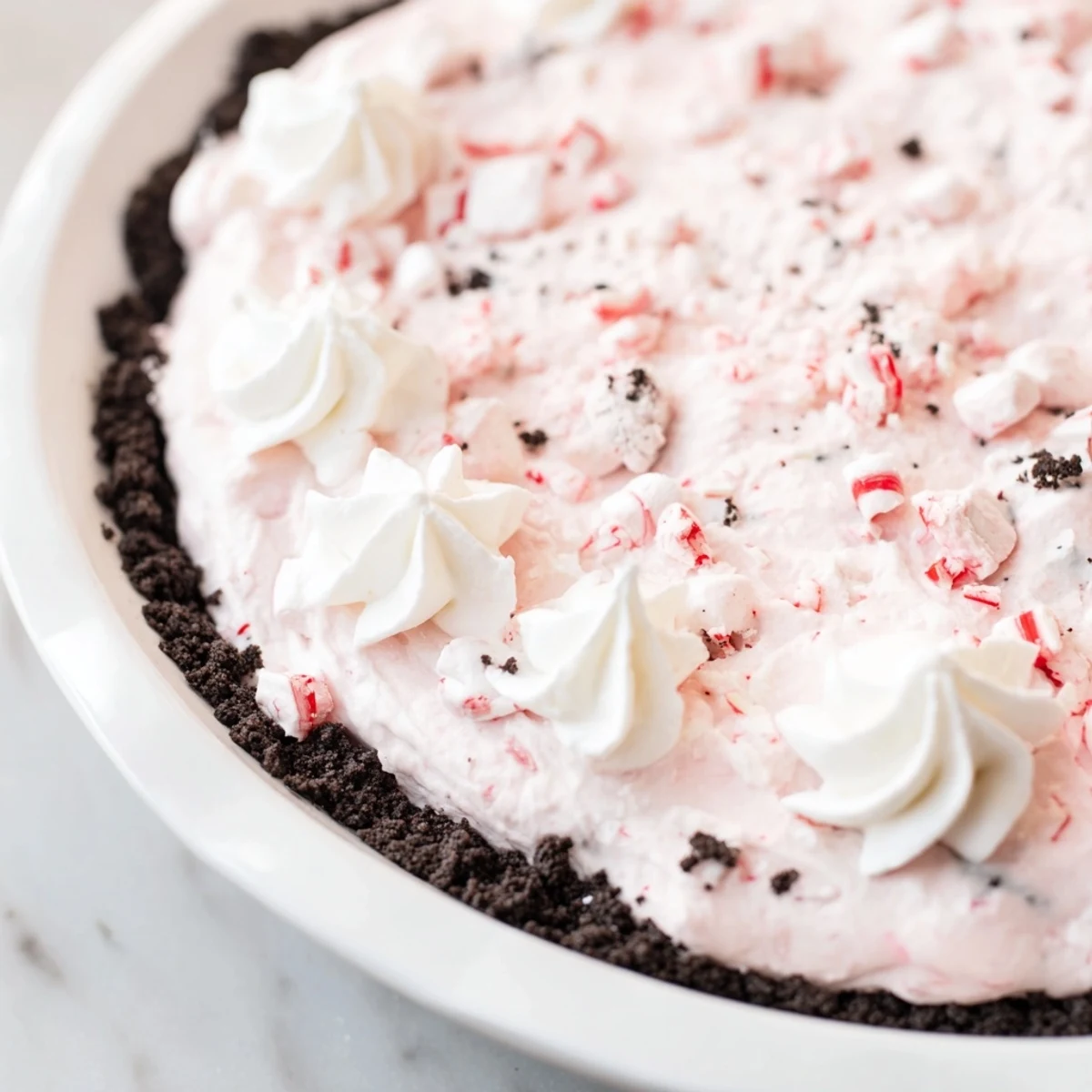 Slice of Candy Cane Pie chilled, airy whipped cream, crunchy peppermint bits