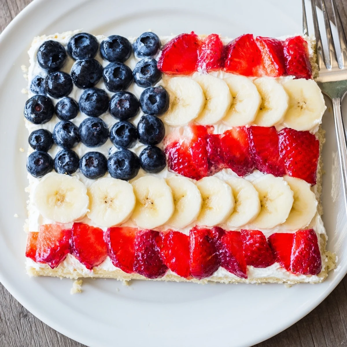 American Flag Fruit Pizza on baking sheet, glossy berries and creamy frosting.
