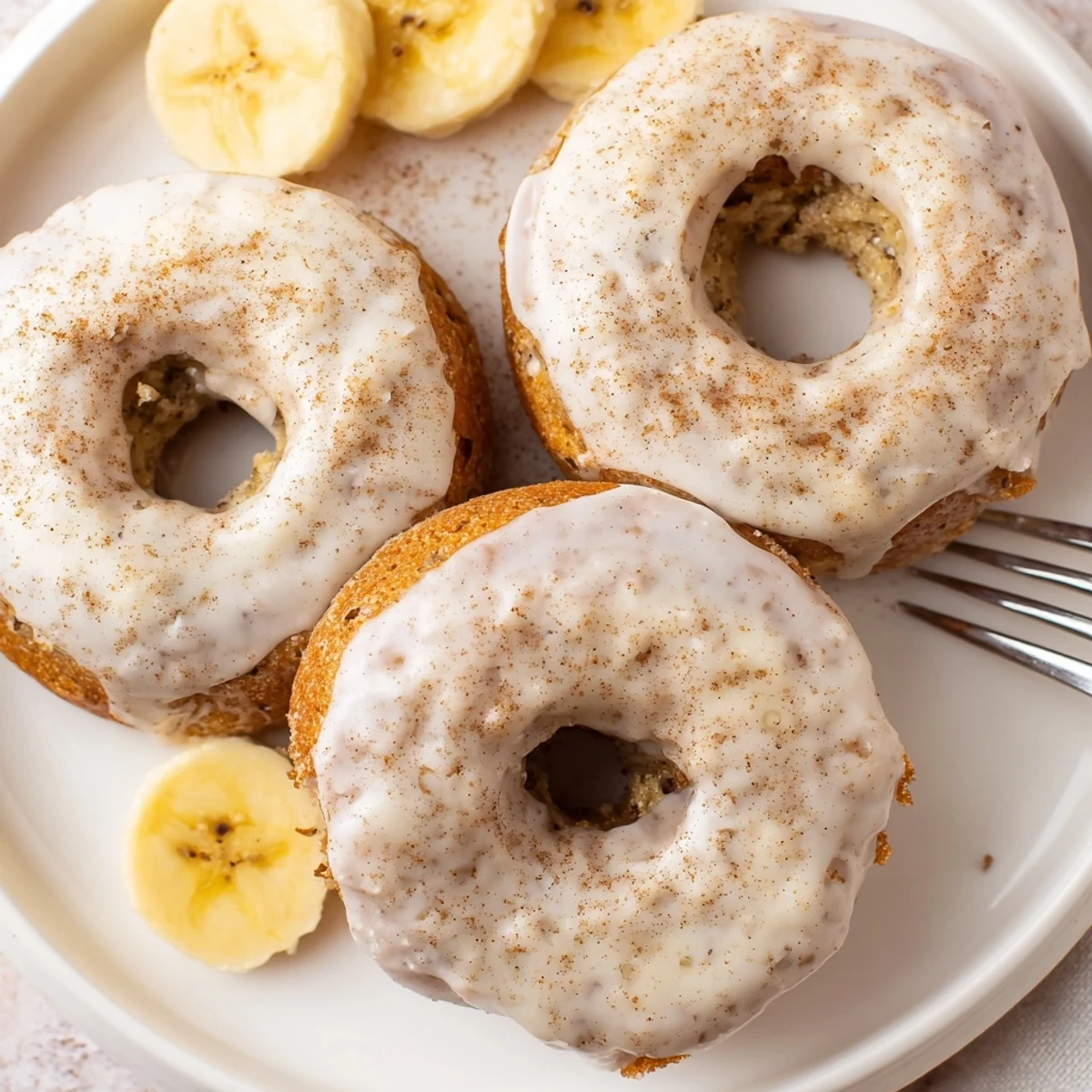 Stacked Banana Donuts dusted with cinnamon sugar, moist centers and aroma.
