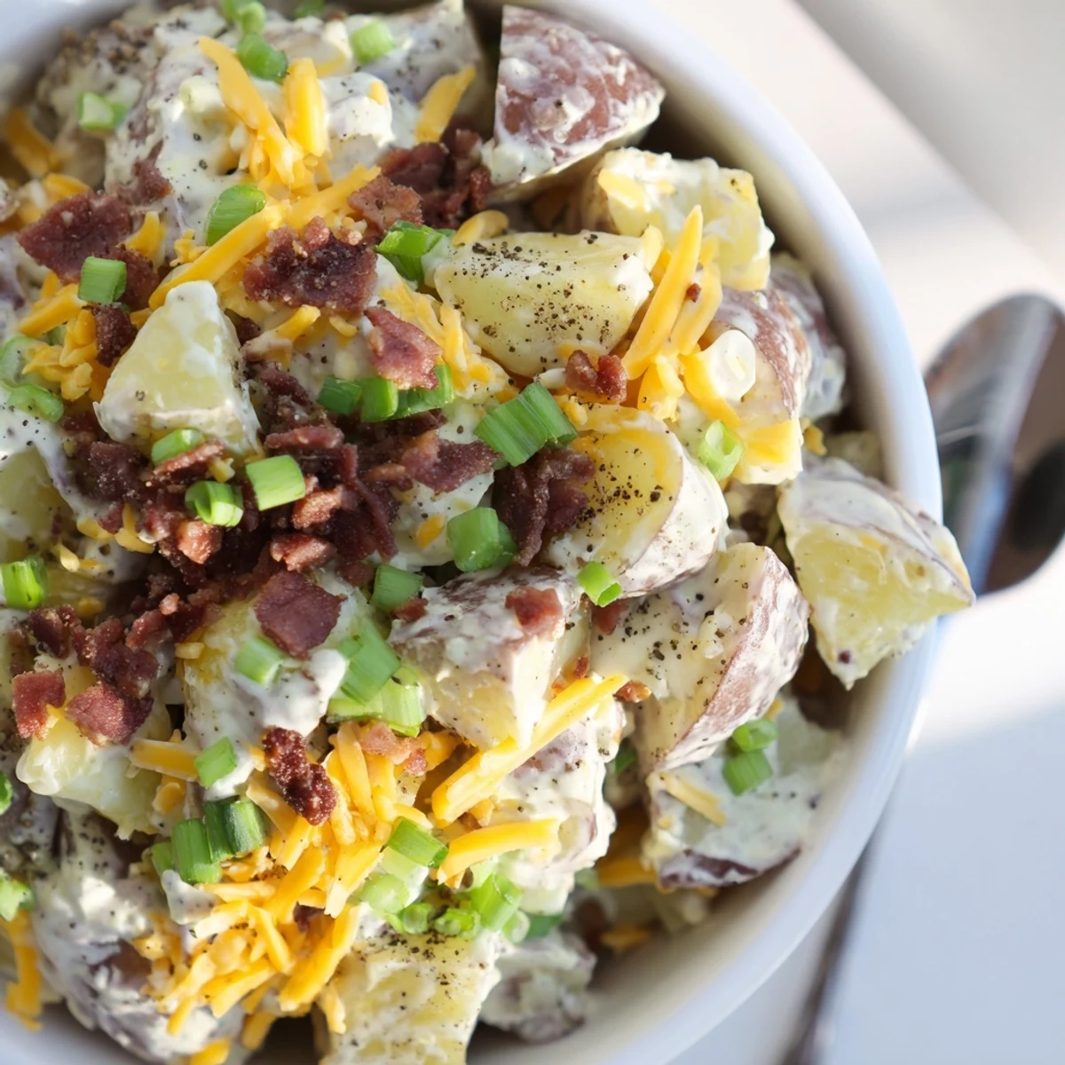 Beef Bacon Loaded Potato Salad piled high, creamy dressing, crispy bacon garnish