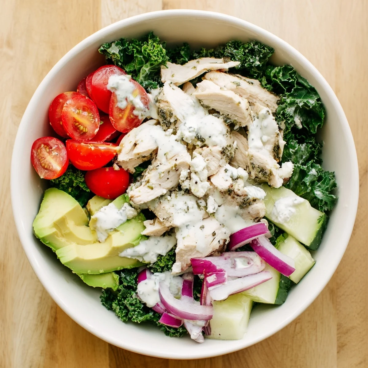 Sliced grilled chicken rests atop crisp kale and vibrant veggies in this nourishing bowl recipe