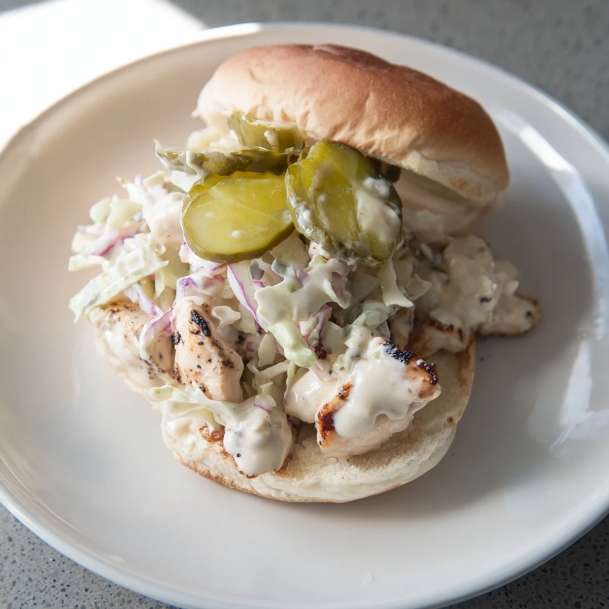 Golden grilled chopped chicken draped in creamy Alabama white BBQ sauce on a toasted bun