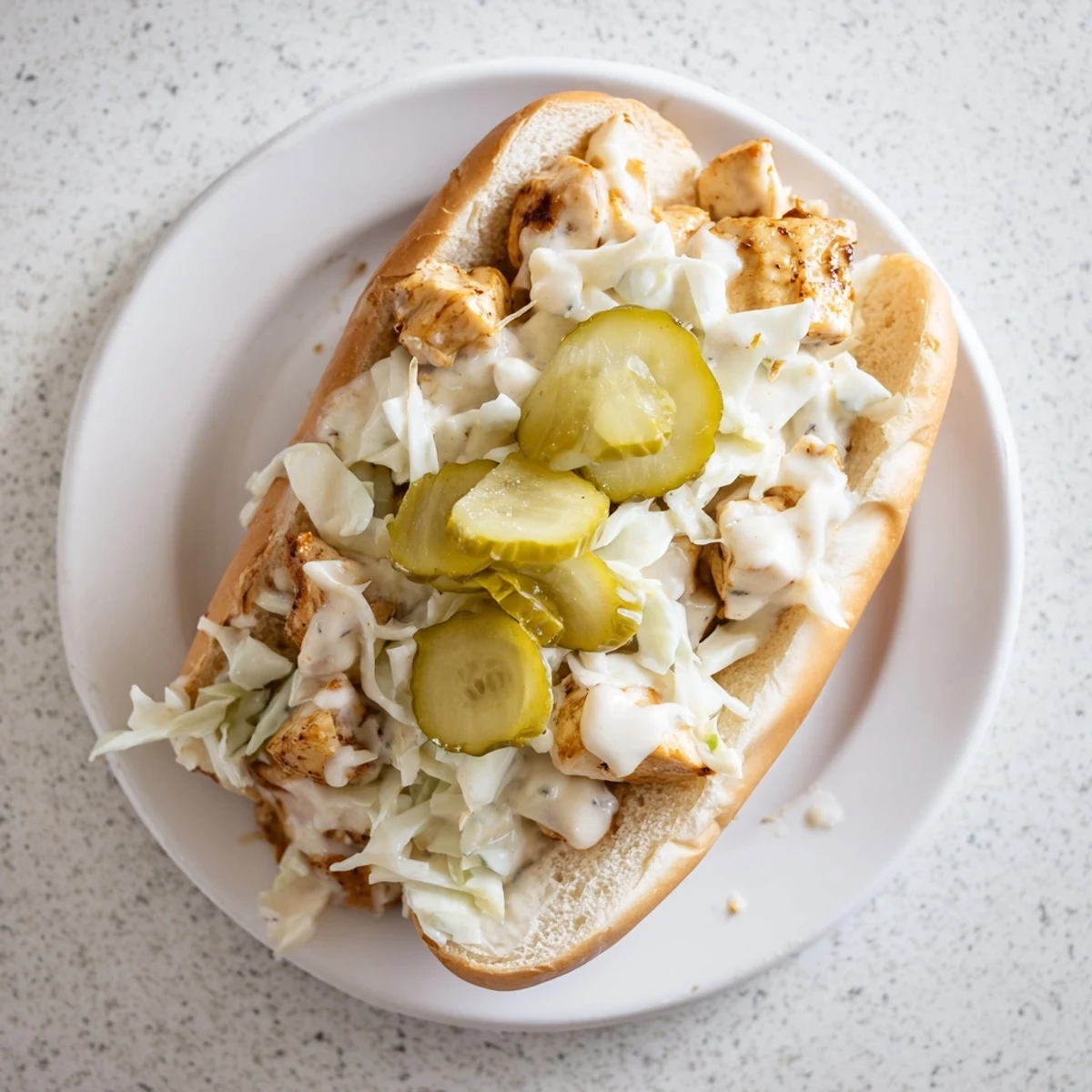 Heaping Alabama BBQ chicken chopped sandwich topped with crisp coleslaw and tangy pickles