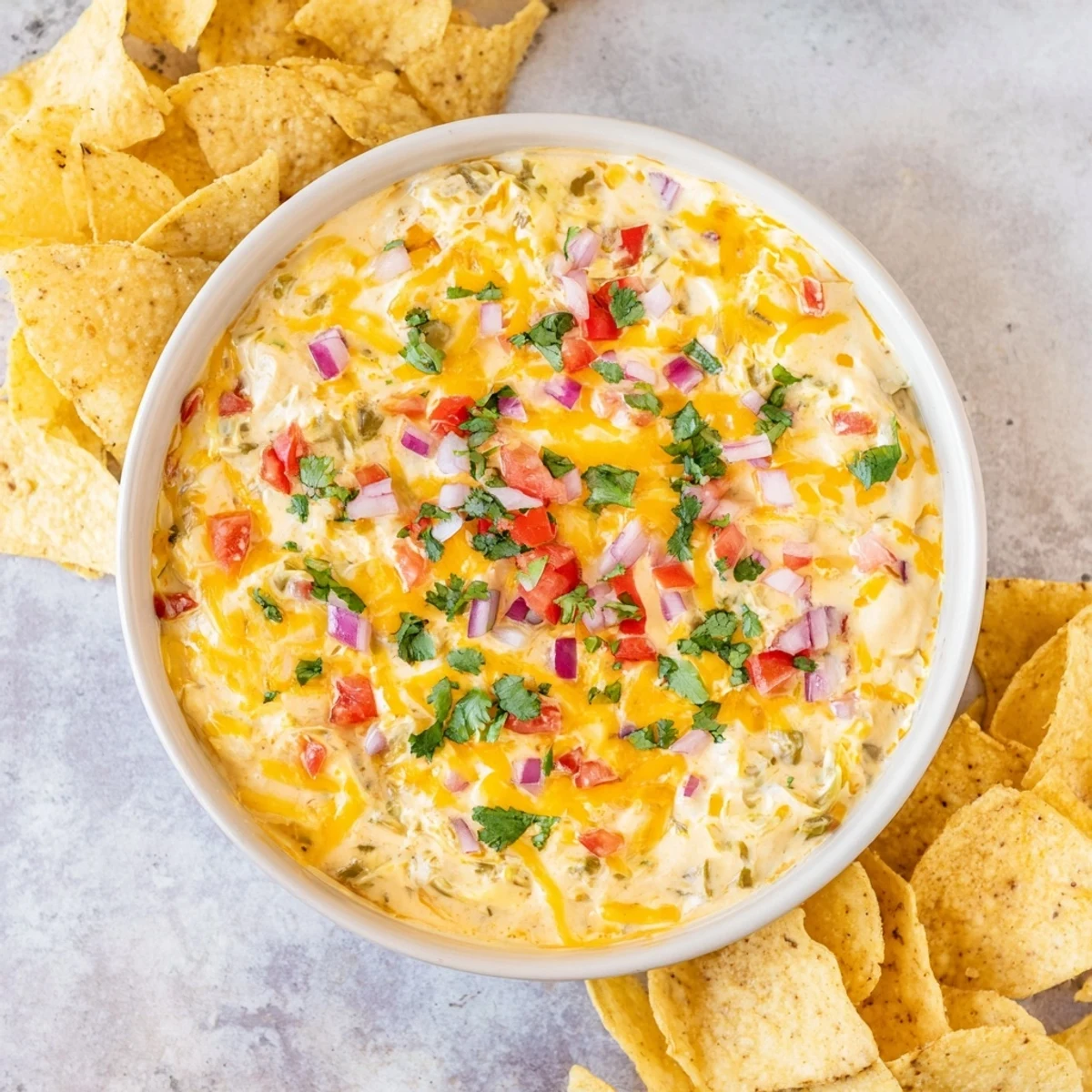 Creamy green chile queso dip topped with fresh cilantro served at a party