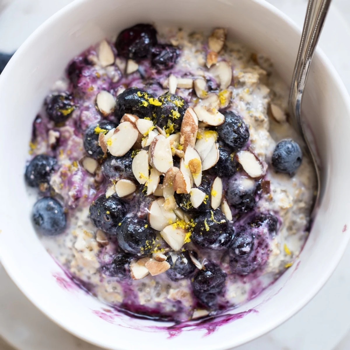 Breakfast-ready Blueberry Lemon Overnight Oats swirled with yogurt and juicy blueberries