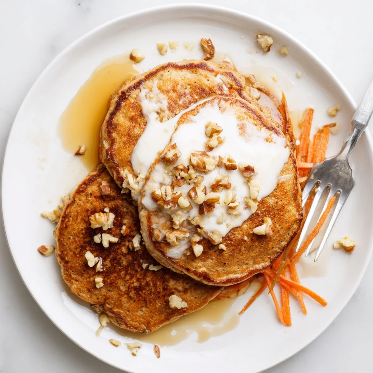 Stack of warm American brunch pancakes studded with shredded carrots and pecans, served with syrup