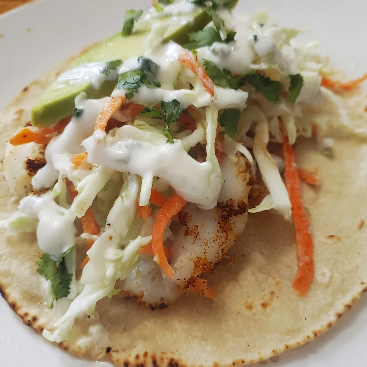 Flaky seasoned cod fillets stuffed into baked cod fish tacos with fresh cilantro and avocado