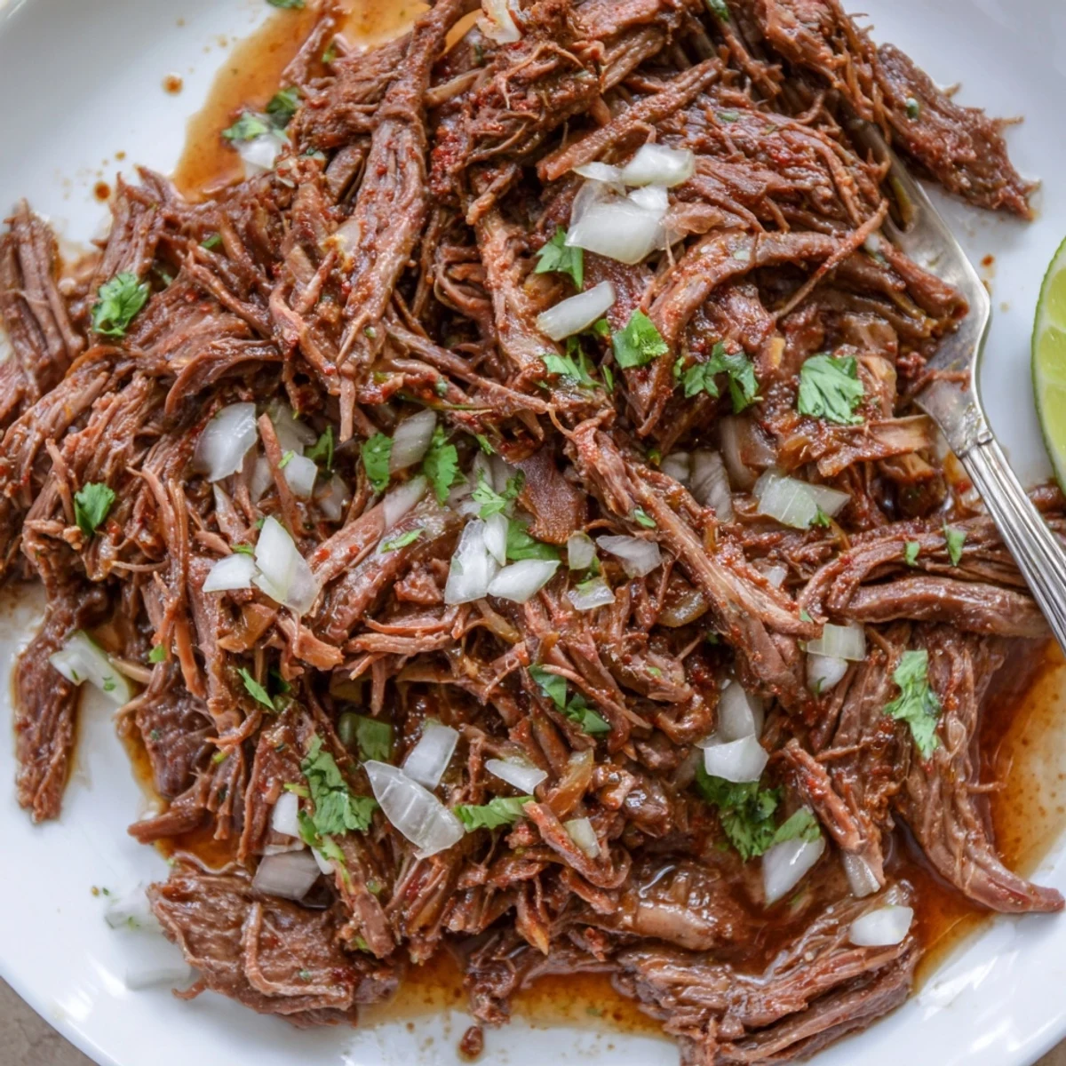 Hearty Slow Cooker Beef Barbacoa served in warm tortillas with lime  